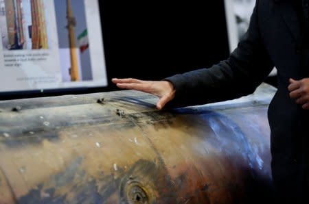 A Middle Eastern journalist touches a missile that the U.S. Defense Department says was manufactured in Iran but that they also claim was fired by Houthi rebels from Yemen into Saudi Arabia in July 2016, as it sits on display at a military base in Washington, U.S., December 13, 2017. Picture taken December 13, 2017. REUTERS/Jim Bourg