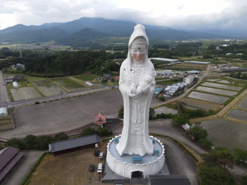 Drone picture shows a mask placed on a 57-metre-high statue of Buddhist goddess Kannon to pray for the end of the coronavirus disease (COVID-19) pandemic at Houkokuji Aizu Betsuin temple in Aizuwakamatsu, Fukushima Prefecture, Japan