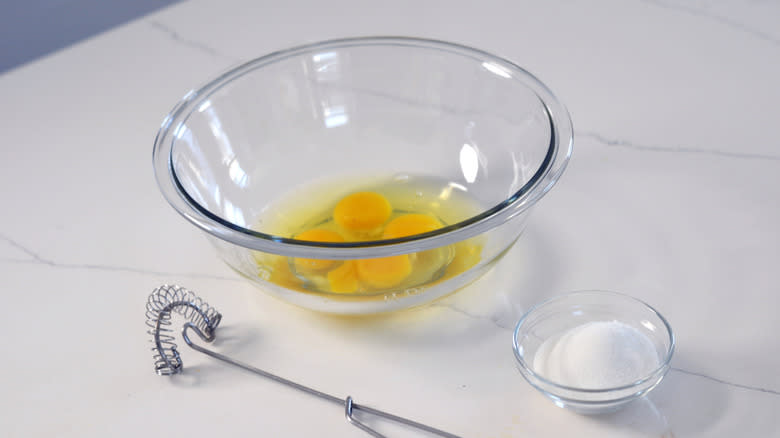 Eggs cracked in a bowl with whisk