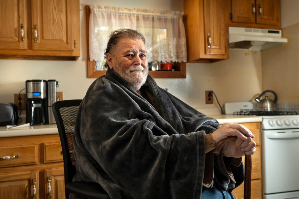 Russ Anderson wears a shawl to help keep warm at his home, Thursday, Oct. 19, 2023, in Waldoboro, Maine. Federal spending to help the poor stay warm may be reduced from last year, a cause for concern in cold-weather states.
