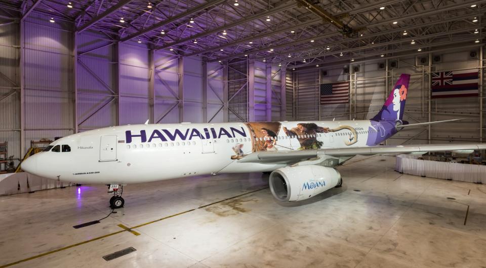 Narrow-body aircraft with Hawaiian logo and markings, in a hangar.