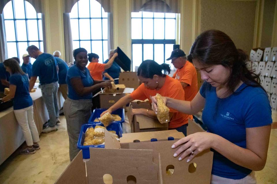 Breakers employee Rocio Chamorro places pasta meals into a box during the inaugural Day of 169,318 Meals packaging event.