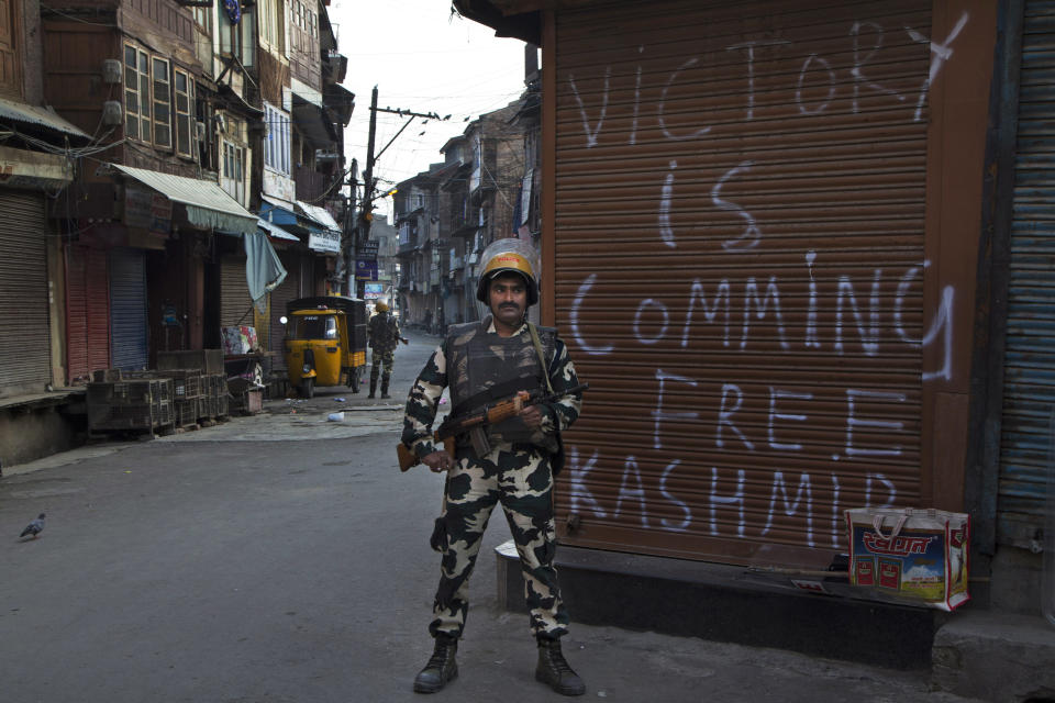 FILE - In this Tuesday, Sept. 13, 2016, file photo, an Indian paramilitary soldier stands guard during curfew enforced to quell protestors in Srinagar, Indian controlled Kashmir. New Delhi initially grappled with largely peaceful anti-India movements in its portion of Kashmir. However, a series of political blunders, broken promises and a crackdown on dissent escalated the conflict into a full-blown armed rebellion against Indian control in 1989 for a united Kashmir, either under Pakistan rule or independent of both. Since then, about 70,000 people have been killed in the conflict, which India sees as a proxy war by Pakistan. (AP Photo/Dar Yasin, File)