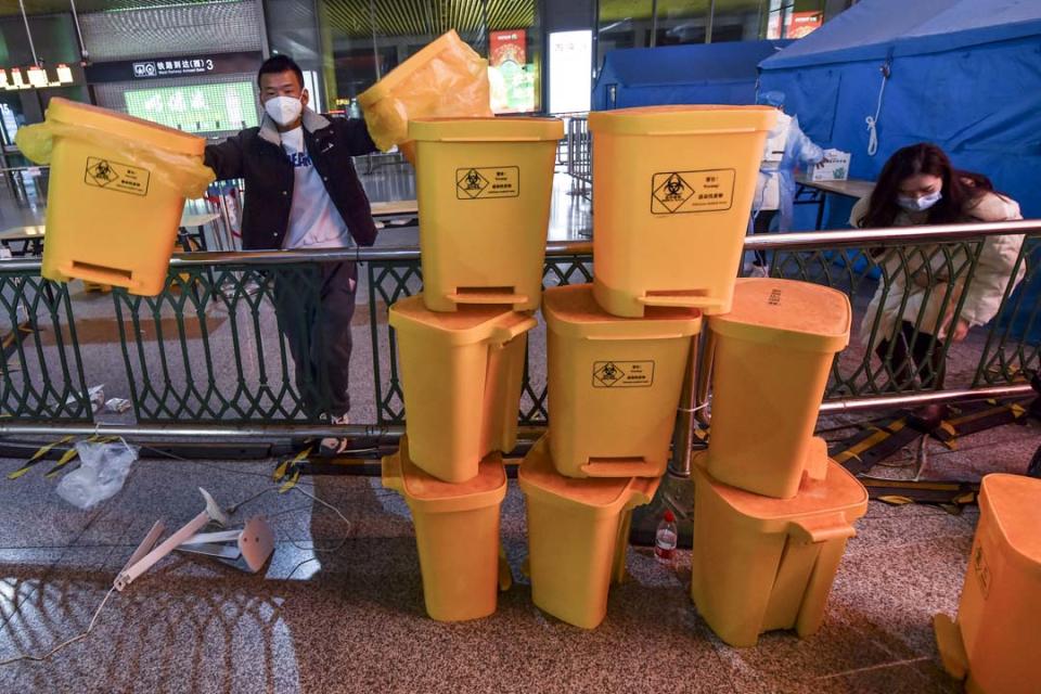 2022年12月7日，中國南京，工作人員在清理高鐵南京南站內的醫療廢料桶。