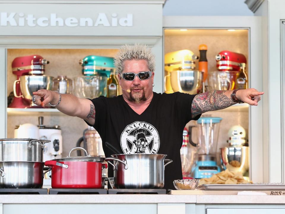 Guy Fieri in the kitchen with pots and pans in front of him