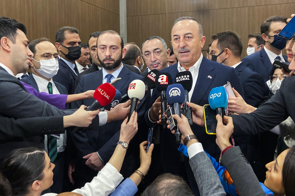 Turkey's Foreign Minister Mevlut Cavusoglu talks to journalists next to his Armenia counterpart Ararat Mirzoyan after their meeting on the sidelines of the Antalya Diplomacy Forum in Antalya, Turkey, Saturday, March 12, 2022. Turkey and Armenia, which have no diplomatic ties, are engaged in talks aimed at ending decades of bitter relations between their two nations. (AP Photo/Mehmet Guzel)