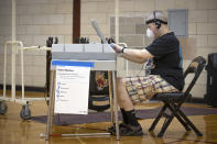 Jason White, who is visually impaired, uses the AutoMARK voting machine to cast his vote at the Roosevelt High School polling location, Tuesday, August 11, 2020 in Minneapolis, Minn. (Elizabeth Flores/Star Tribune via AP)