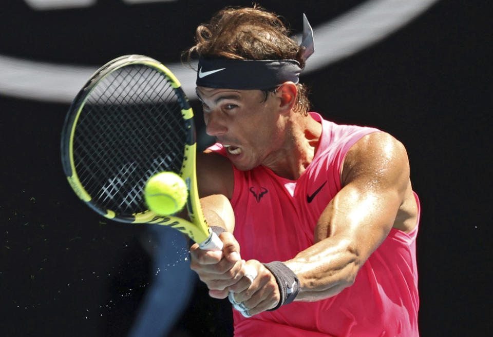 Spain's Rafael Nadal makes a backhand return to Bolivia's Hugo Dellien during their first round singles match at the Australian Open tennis championship in Melbourne, Australia, Tuesday, Jan. 21, 2020. (AP Photo/Lee Jin-man)