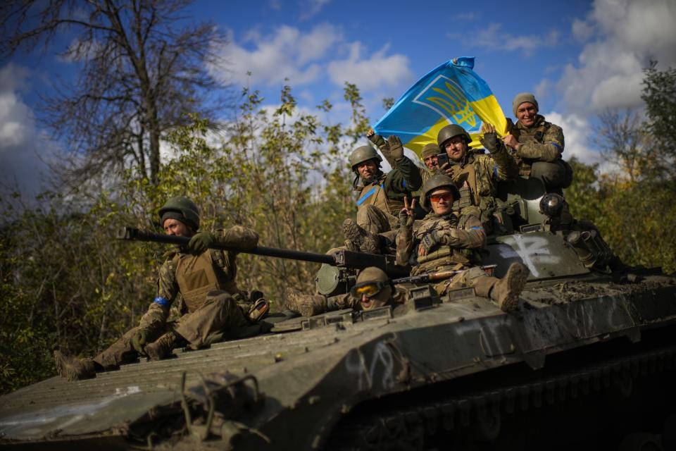 FILE - Ukrainian soldiers sit on an armoured vehicle as they drive on a road between Izium and Lyman, recently retaken areas in Ukraine, on Oct. 4, 2022. Ukraine has successfully pressed its counteroffensive, forcing Russian troops to retreat in several areas of the east and the south. (AP Photo/Francisco Seco, File)