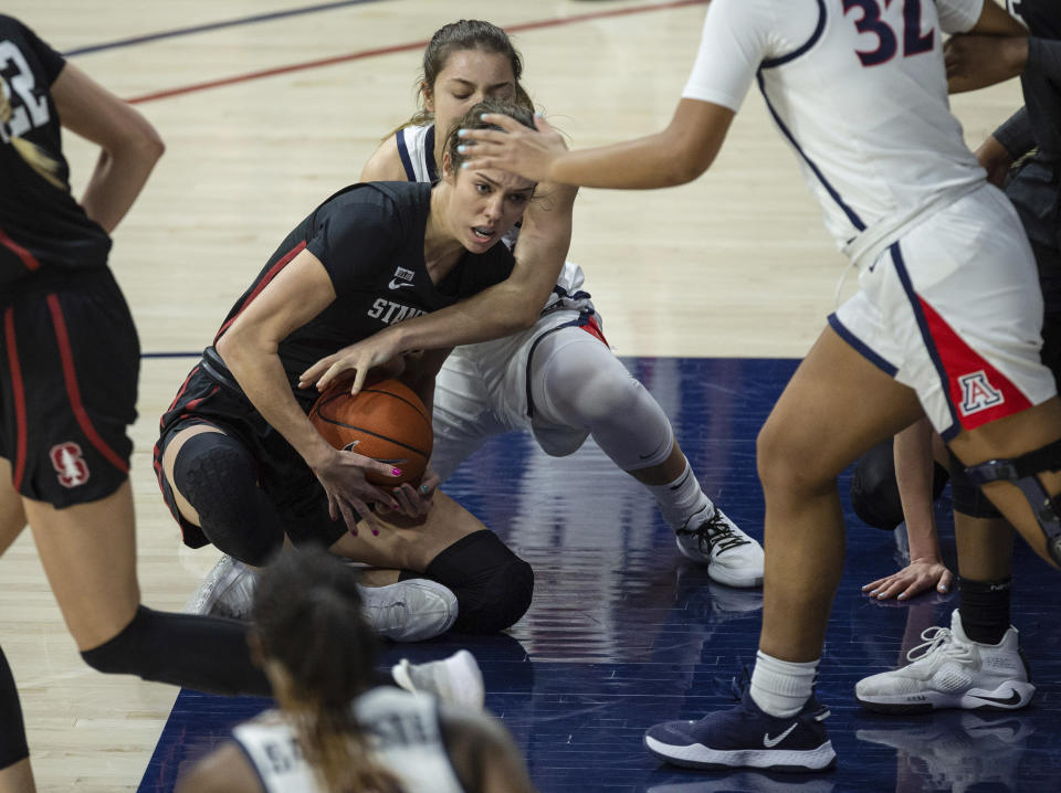 Stanford guard Lacie Hull (24) holds on tight to the ball following a floor scramble with Arizona guard Helena Pueyo, back, during an NCAA college basketball game Friday, Jan. 1, 2021, in Tucson, Ariz. (Josh Galemore/Arizona Daily Star via AP)