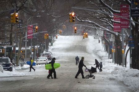 A mostly deserted 5th Avenue is pictured during what would normally be a busy rush hour morning following Winter Storm Juno in the Manhattan borough of New York January 27, 2015. A blizzard swept across the northeastern United States, dropping more than a foot (30 cm) of snow but falling short of more dire predictions that sent workers and students home, halted thousands of flights and prompted New York officials to ban cars from roads and shut down subway trains. REUTERS/Carlo Allegri