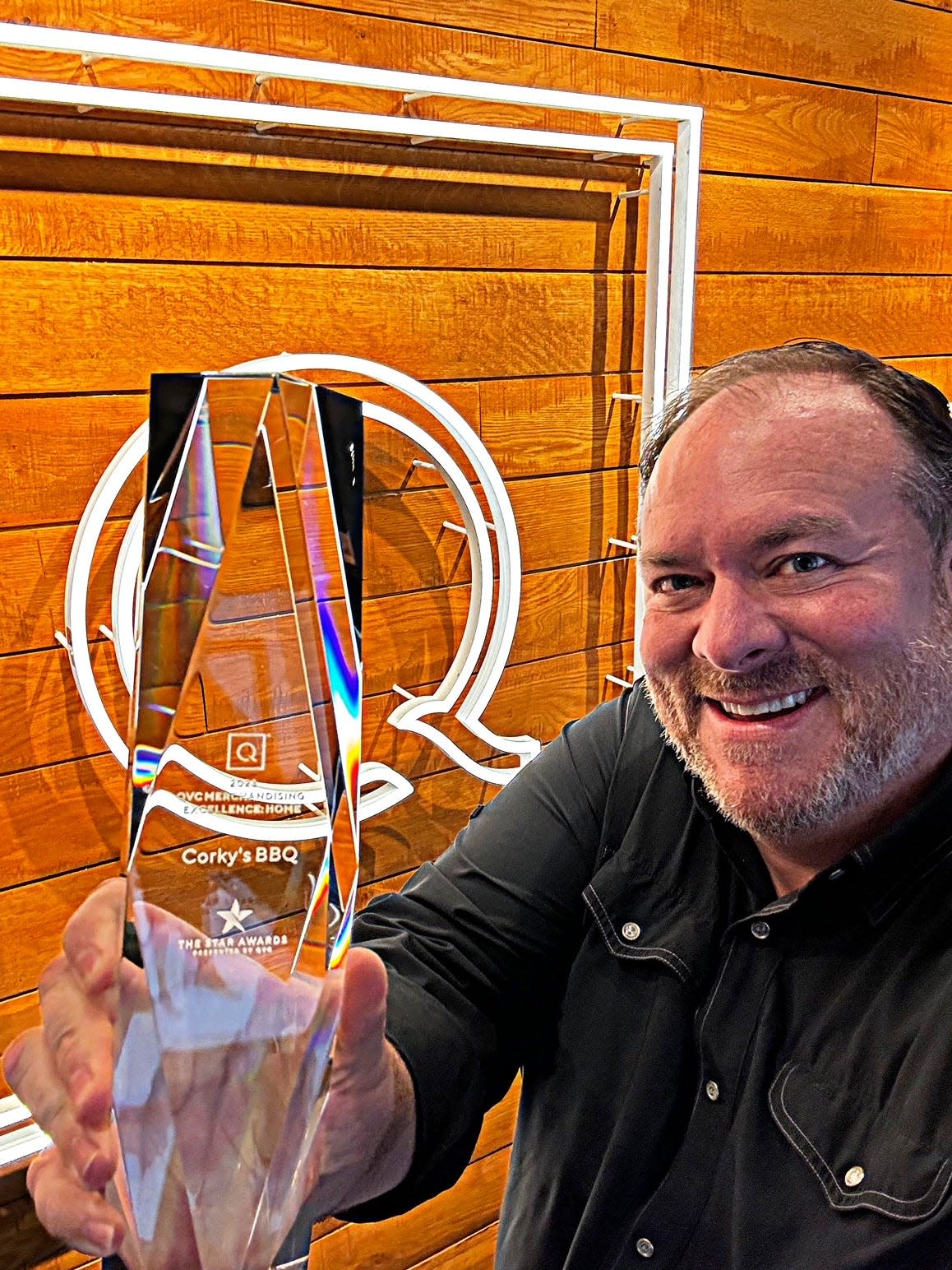 Corky’s BBQ owner Jimmy Stovall holds the trophy for the 2024 QVC Star Award for Merchandising Excellence that was awarded to the Memphis-based barbecue restaurant.
