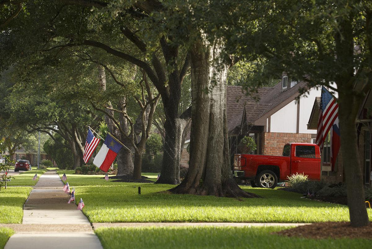 Residents put up flags for the Fourth of July in a neighborhood on the south side of Pasadena on July 1, 2017.