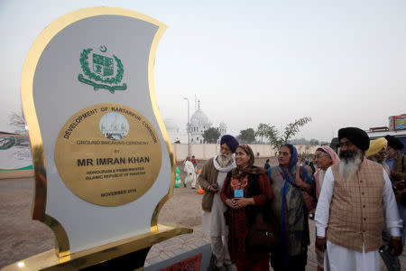 Sikhs from India look at the inaugural foundation plaque near the shrine of Guru Nanak Dev Ji, founder of Sikhism, during the groundbreaking ceremony of the Kartarpur border corridor, which will officially open next year, in Kartarpur, Pakistan November 28, 2018. REUTERS/Mohsin Raza