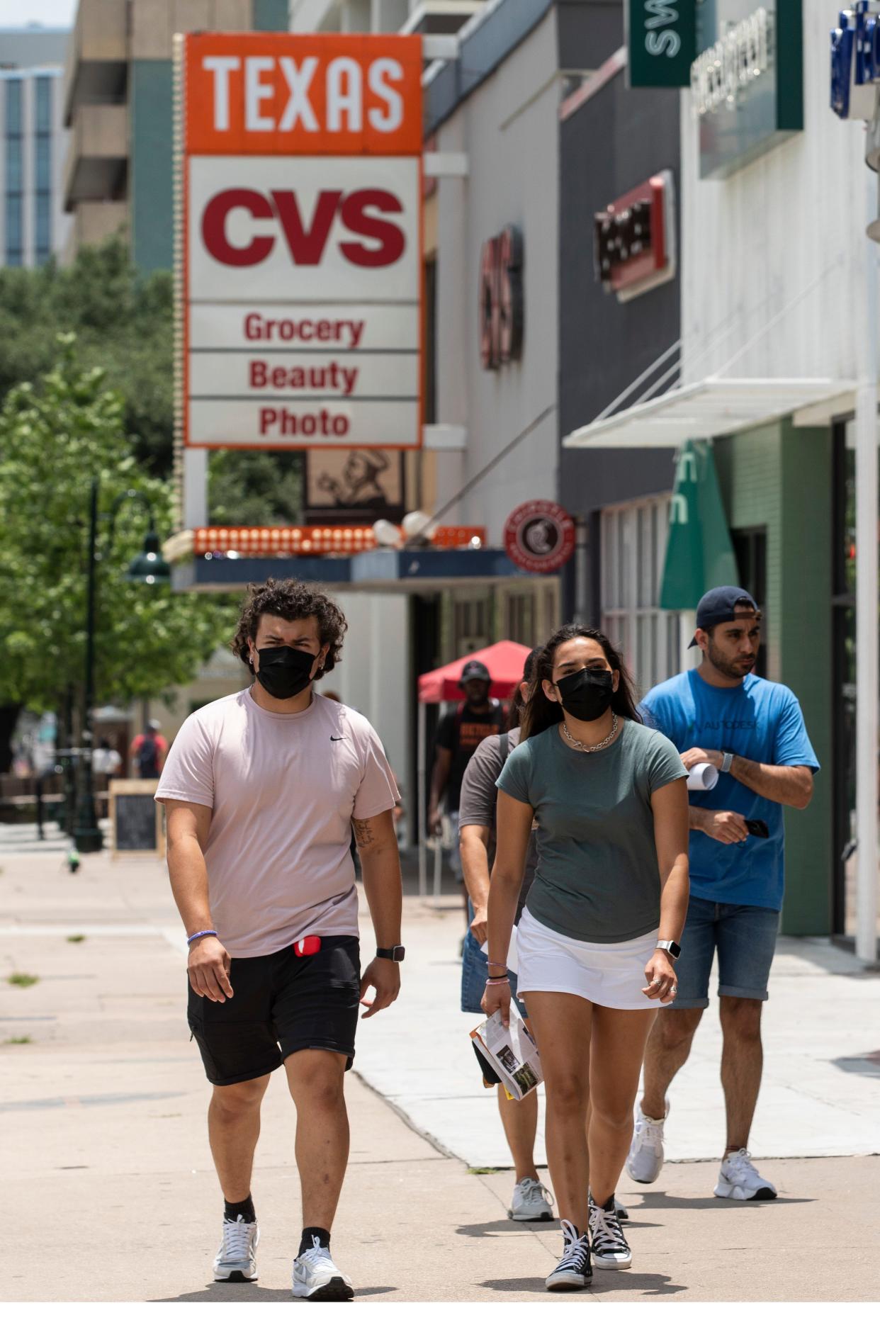 People wear masks as they walk along the Drag near the University of Texas in July 2021, during a surge in COVID-19 cases. Today, the CDC only recommends wearing masks five days immediately following an infection.