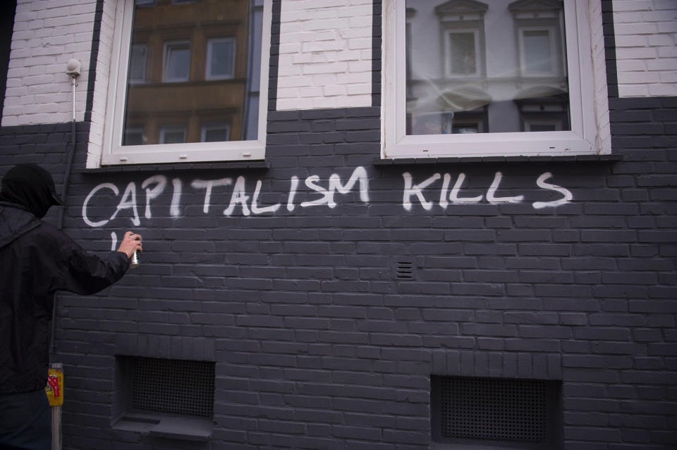 <p>A protester writes on the wall on July 7, 2017 in Hamburg, northern Germany, where leaders of the world’s top economies gather for a G20 summit. (Photo: Steffi Loos/AFP/Getty Images) </p>