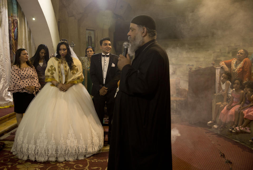 In this June 15, 2019 photo, a Coptic priest burns incense as an Egyptian couple is married in St. Samaan's Church, in the predominantly Christian Manshiyat Nasser area of Cairo, Egypt. Egypt’s legal system grants the Coptic church full authority over personal status matters of Copts, namely marriage and divorce. But the church does not have the same powers over its followers’ inheritance rights. (AP Photo/Maya Alleruzzo)