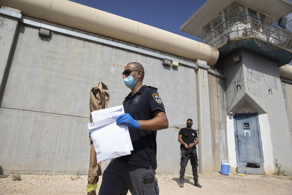 Police officers and prison guards inspect the scene of a prison escape outside the Gilboa prison in northern Israel, Monday, Sept. 6, 2021. Israeli forces on Monday launched a massive manhunt in northern Israel and the occupied West Bank after several Palestinian prisoners escaped overnight from the high-security facility in an extremely rare breakout. (AP Photo/Sebastian Scheiner)