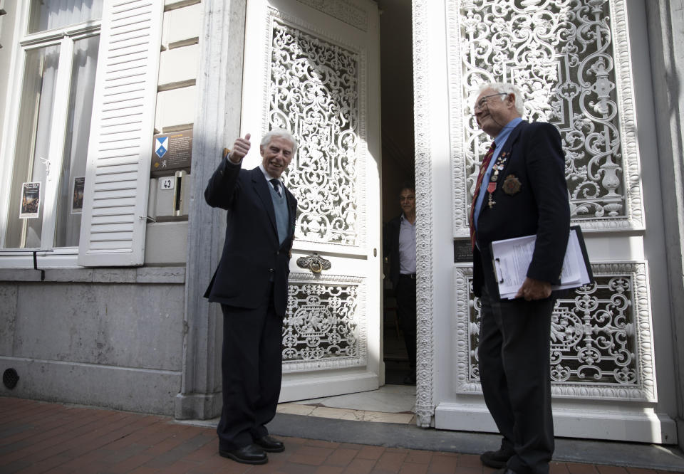 British RAF veteran George Sutherland, 98, left, gives the thumbs up as he arrives at Talbot House with his son Alex Sutherland, after taking part in a VE Day charity walk to raise funds for Talbot House in Poperinge, Belgium, Friday, May 8, 2020. Sutherland walked from the Lijssenthoek war cemetery to Talbot house to raise money for the club which is currently closed due to coronavirus lockdown regulations. The club, founded in 1915 was a place for British soldiers to rest during both the First and Second World Wars. (AP Photo/Virginia Mayo)