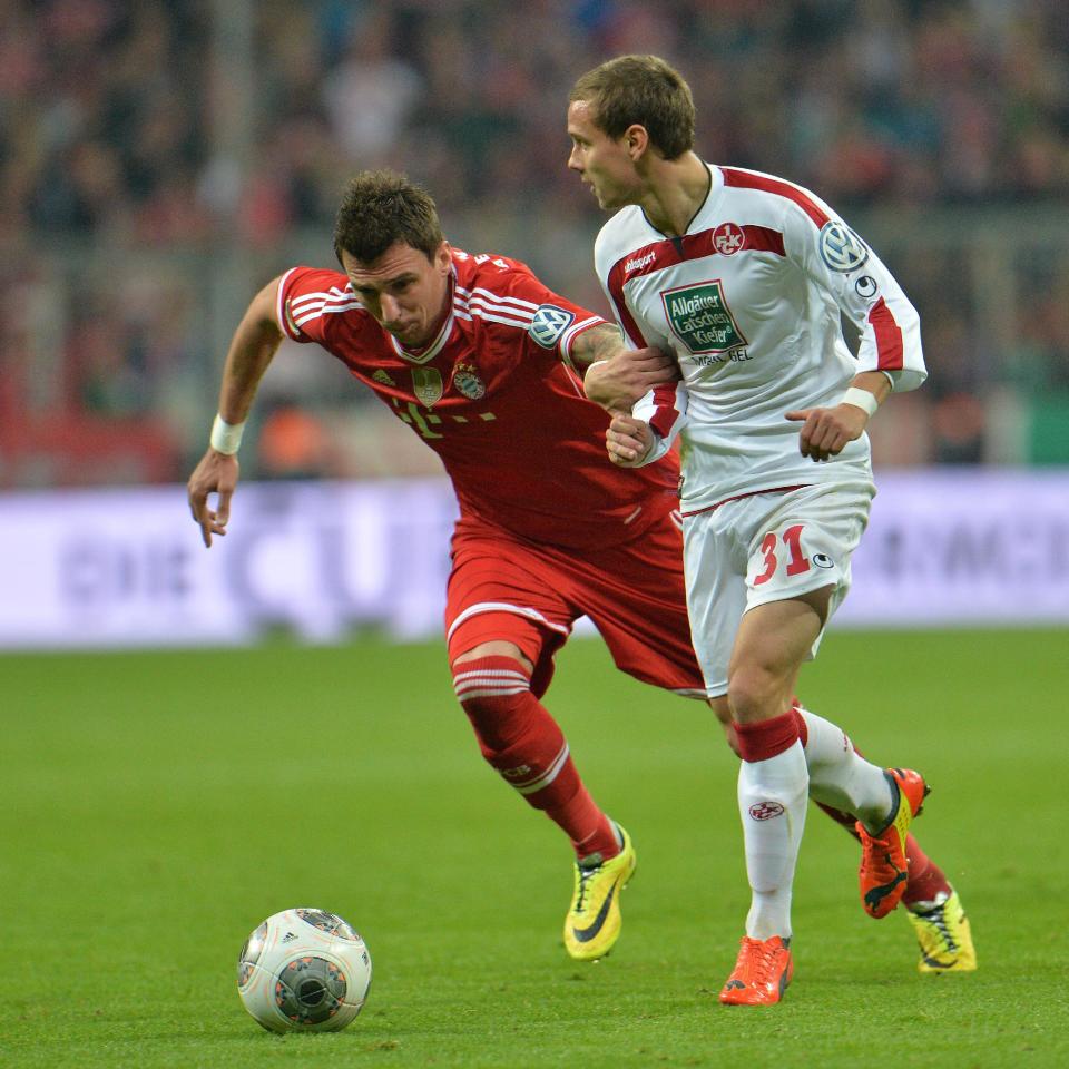 Munich's Mario Mandzukic of Croatia, left, and Kaiserslautern's Chris Loewe challenge for the ball during the German soccer cup (DFB Pokal) semifinal match between FC Bayern Munich and FC Kaiserslautern in the Allianz Arena in Munich, Germany, on Wednesday, April 16. 2014. (AP Photo/Kerstin Joensson)