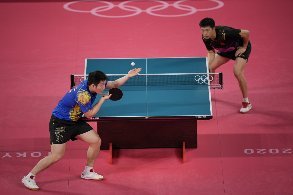 Fan Zhendong of China, left, prepares to serve to Ma Long of China during a gold medal match of the table tennis men's singles against at the 2020 Summer Olympics, Friday, July 30, 2021, in Tokyo. (AP Photo/Kin Cheung)