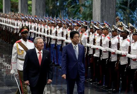 Cuba's President Raul Castro (C) and Japan's Prime Minister Shinzo Abe (R) review the honor guard during an official reception ceremony at Havana's Revolution Palace, Cuba September 22, 2016. REUTERS/Enrique de la Osa