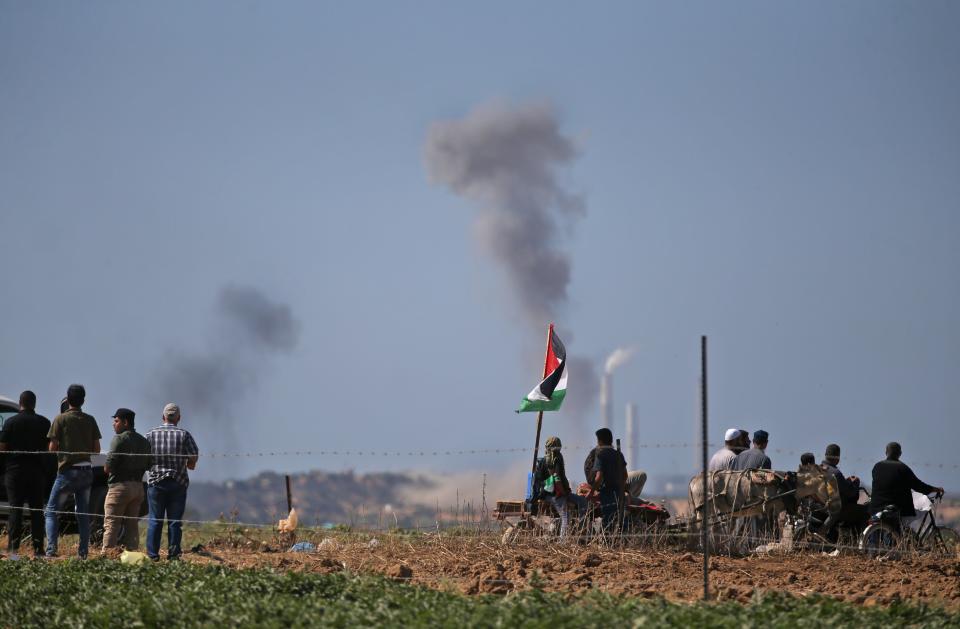 Palestinians look at smoke billowing from the site of an Israeli air strike on a Hamas' military site in Beit Lahia near the border between Israel and the Gaza Strip, east of Jabalia on May 14, 2018.