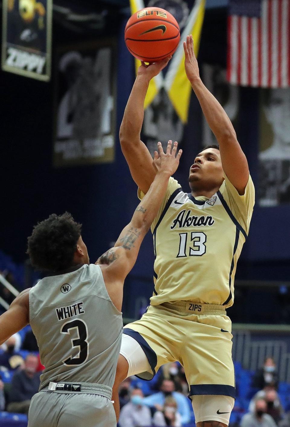 Akron Zips guard Xavier Castaneda (13) attempts a shot over Western Michigan Broncos guard B. Artis White (3) during the first half of an NCAA basketball game, Tuesday, Jan. 18, 2022, in Akron, Ohio. [Jeff Lange/Beacon Journal]