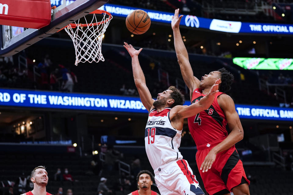 Washington Wizards guard Raul Neto (19) shoots in front of Toronto Raptors forward Scottie Barnes (4) during the first half of a preseason NBA basketball game Tuesday, Oct. 12, 2021, in Washington. (AP Photo/Alex Brandon)