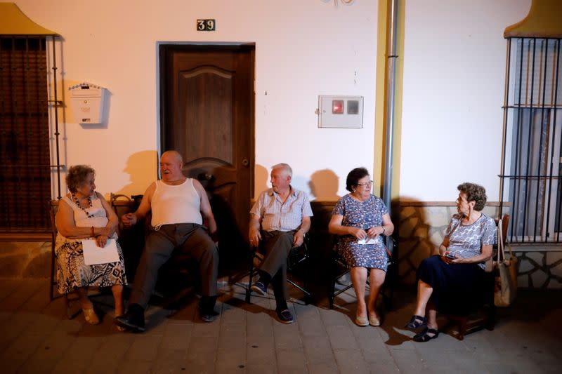 FILE PHOTO: Neighbours try to avoid heat on summer night in Algar