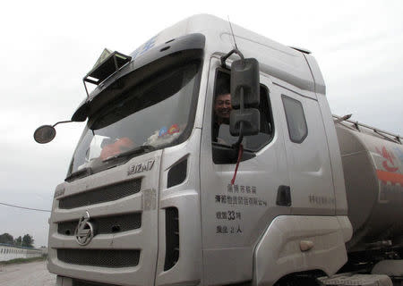 Wang Xiaojun, a truck driver, smiles at camera in a truck in Zibo, Shandong Province, China, May 11, 2016. REUTERS/Meng Meng