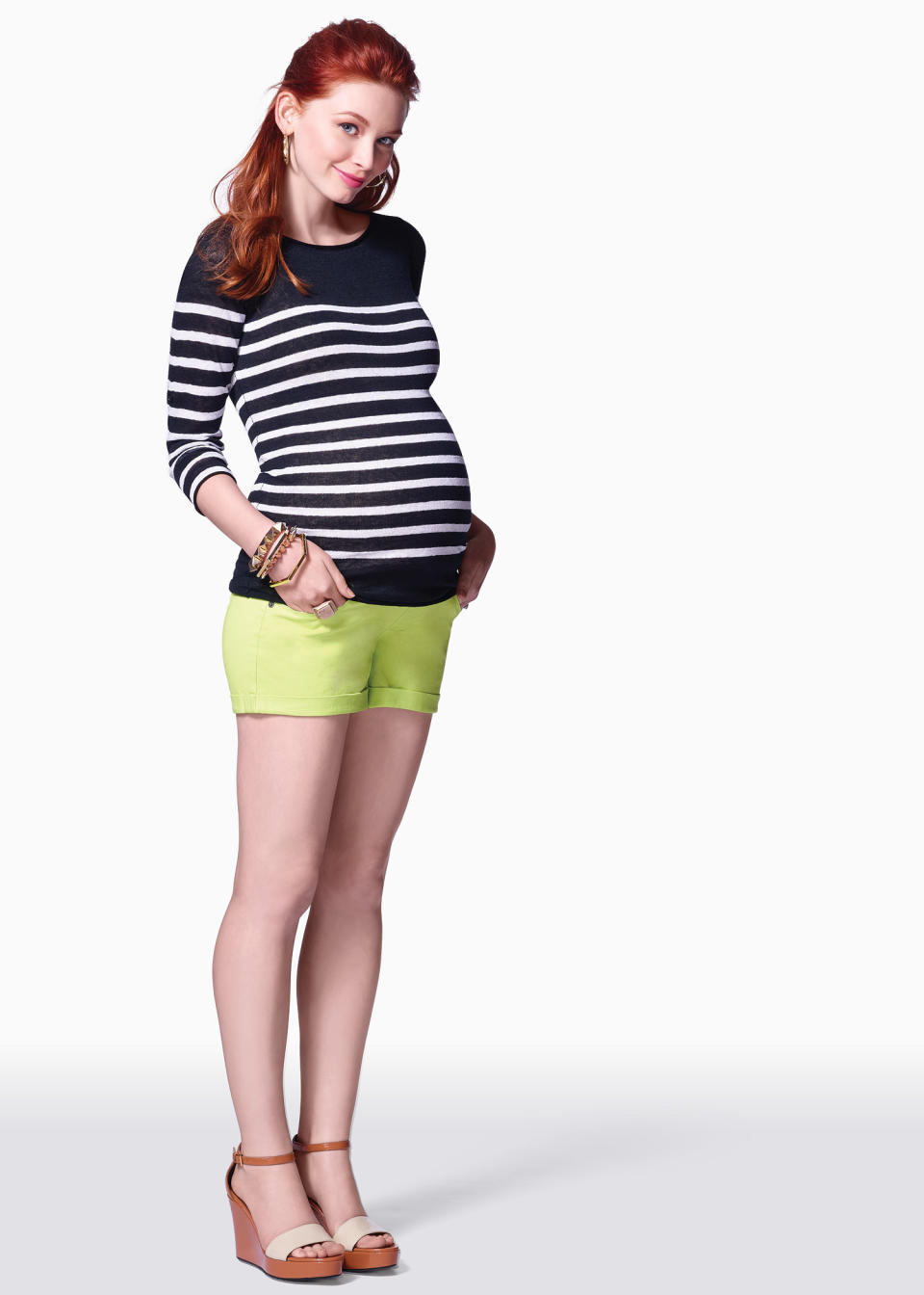 This product image released by maternity clothing company Pea in the Pod shows a model sporting shorts and a black and white striped top. Fashion experts say a streamlined style best suits a baby bump. (AP Photo/Pea in the Pod)