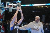 Osceola Magic's Mac McClung holds the trophy as he is congratulated by Julius Erving after McClung won the slam dunk competition at the NBA basketball All-Star weekend, Saturday, Feb. 17, 2024, in Indianapolis. (AP Photo/Darron Cummings)