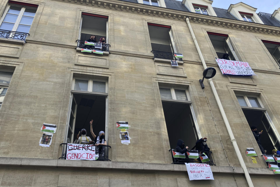 Students blocking the Sciences-Po university look out Friday, April 26, 2024 in Paris. Students at a prestigious university resumed pro-Palestinian protests on Friday, days after French police broke up a demonstration, inspired by Gaza solidarity encampments at campuses around the United States. Dozens of students the Sciences-Po university blocked an entrance to a campus building in central Paris with chairs and bikes. (AP Photo/Jeffrey Schaeffer)