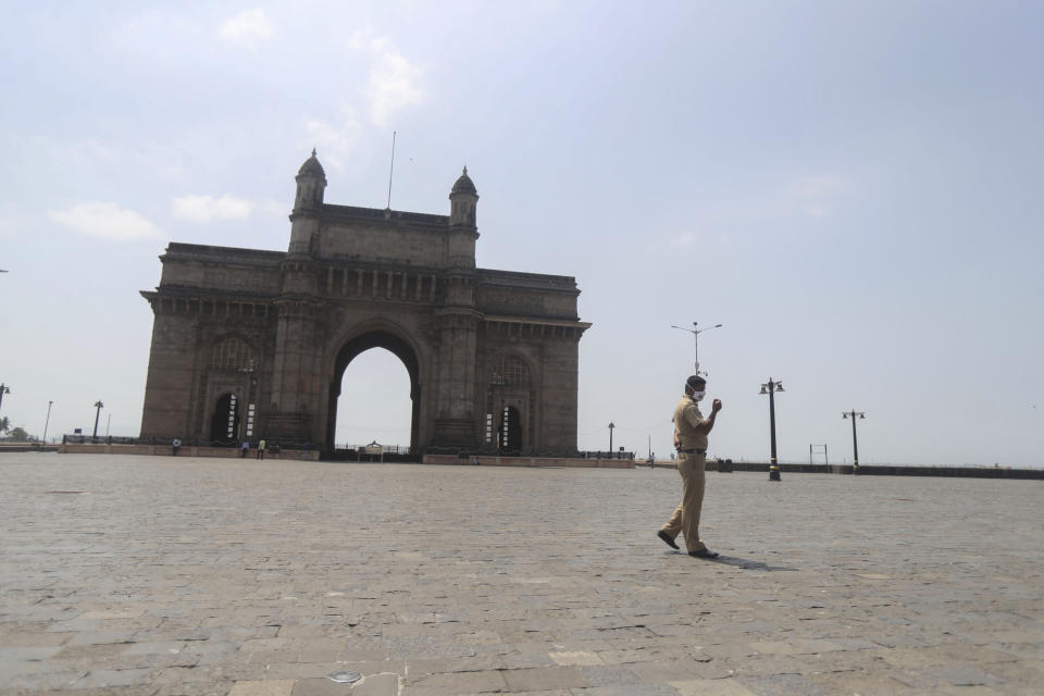 An Indian police officer wearing mask patrols at the Gateway of India in Mumbai, India, Monday, April 5, 2021. India reported its biggest single-day spike in confirmed coronavirus cases since the pandemic began Monday, and officials in the hard-hit state home to Mumbai are returning to the closure of some businesses and places of worship in a bid to slow the spread. (AP Photo/Rafiq Maqbool)