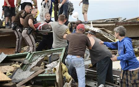 Rescue workers help free one of 15 people trapped in a medical building at the Moore hospital complex after a tornado tore through the area of Moore, Oklahoma in this file photo from May 20, 2013. REUTERS/Gene Blevins/Files