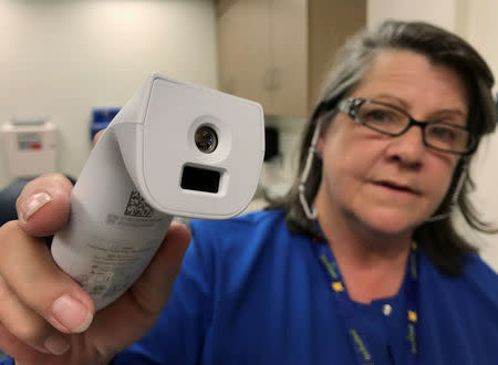 Registered nurse Tara McCormick, Clinical Services Manager, demonstrates an infrared thermometer at West Virginia University Hospital in Morgantown, West Virginia, U.S., September 6, 2017. Photo taken September 6, 2017. REUTERS/Mike Wood