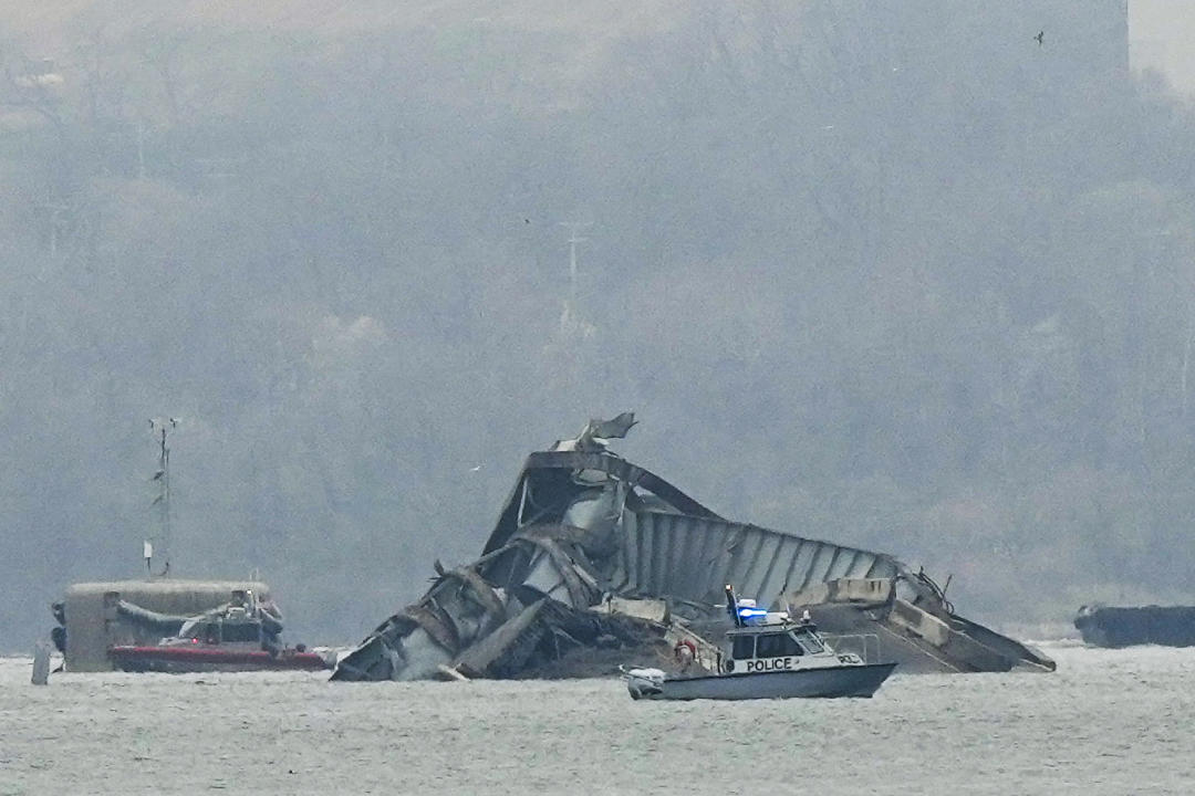 Several boats near the wreckage of the Key Bridge.