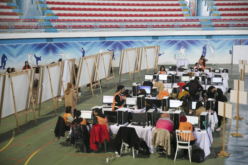 Members of the Independent Higher Authority for Elections count the votes one day after the parliamentary elections in Tunis, Tunisia, Sunday, Dec. 18, 2022. (AP Photo/Hassene Dridi)