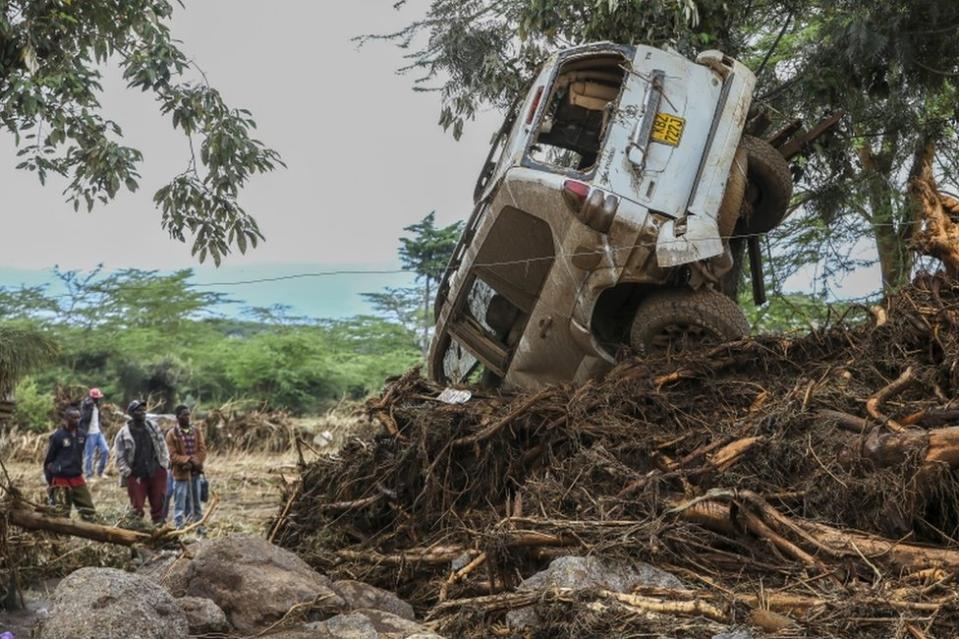 People look at a car damaged after flash floods in Mai Mahiu in the Rift Valley region of Naivasha, Kenya, April 30.