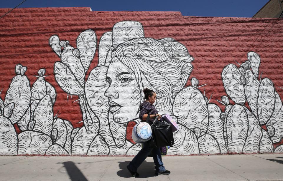 A woman walks past one of many murals in the Segundo Barrio of El Paso  Sept., 12, 2019. The neighborhood is a mixed-use residential and commercial neighborhood in south El Paso.