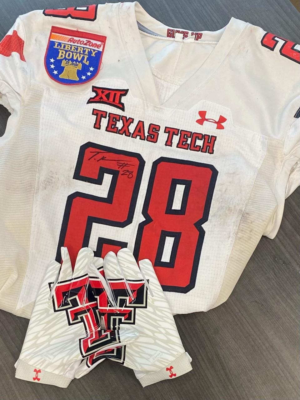 Coach James Keller on May 7, 2024 shows off this signed Texas Tech jersey and gloves belonging to former Manor Mustang Tajh Brooks, who is expected to be drafted next year.