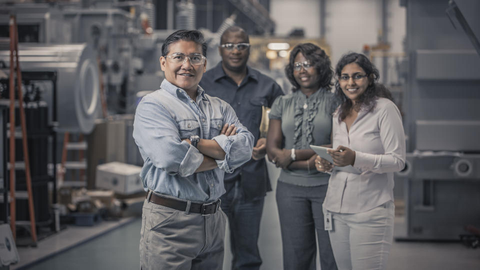 Workers in STEM standing together in factory