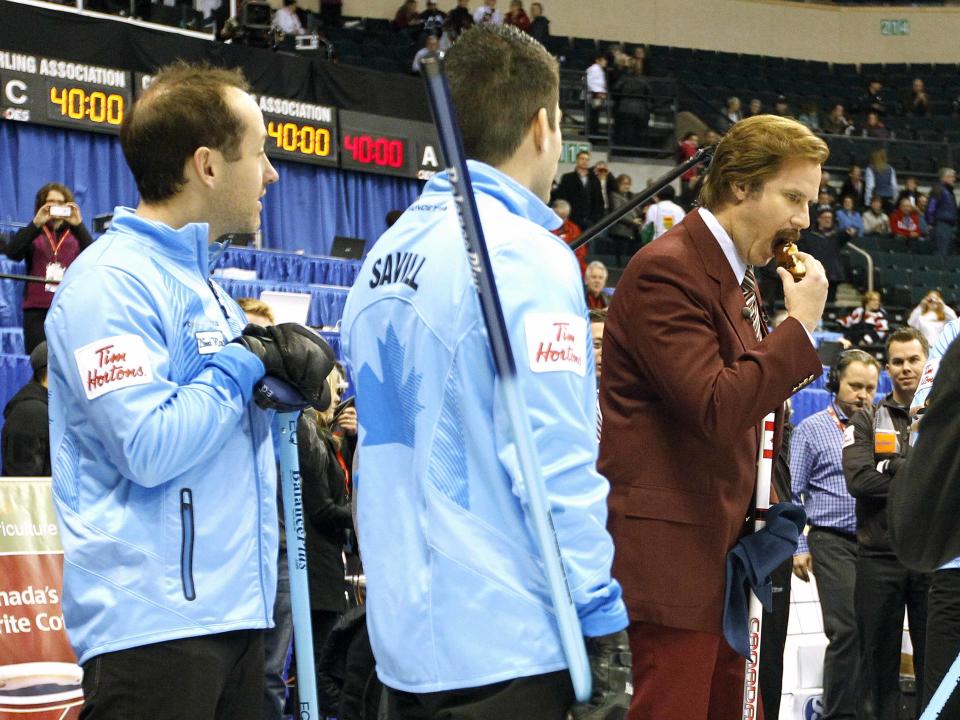 Actor Will Ferrell as Ron Burgundy enjoys a donut with Team Howard prior to the start of the Roar of the Rings Canadian Olympic Curling Trials in Winnipeg, Manitoba December 1, 2013. REUTERS/Trevor Hagan (CANADA - Tags: SPORT ENTERTAINMENT CURLING)