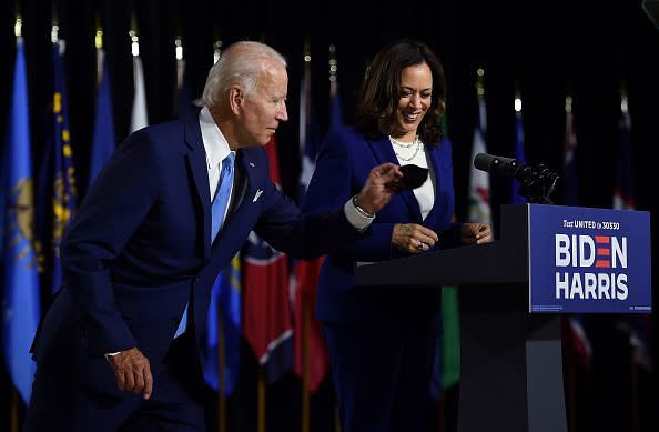 Democratic presidential nominee and former US Vice President Joe Biden grabs his mask afte rintroducing his vice presidential running mate, US Senator Kamala Harris, during their first press conference together in Wilmington, Delaware.