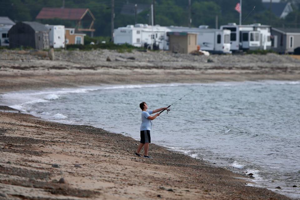 A man casts his line from the beach at East Beach in Westport.