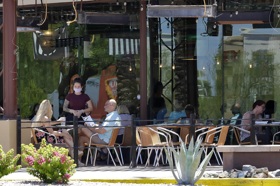 FILE - In this May 13, 2020 file photo guests dine in-house at a restaurant in Phoenix. As coronavirus cases continue to surge in Arizona, the governor shows no signs of tightening restrictions such as forcing the use of face masks. (AP Photo/Matt York,File)
