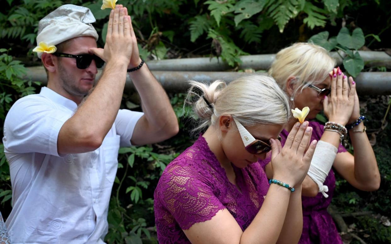 Sabina Dolezalova (centre) and her boyfriend Zdenek Slouka pray ahead of a purification ritual - AFP