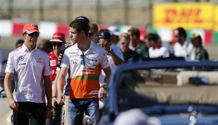 McLaren Formula One driver Jenson Button (L) of Britain and Force India Formula One driver Paul di Resta of Britain walk followed by other drivers during the drivers' parade before the Japanese F1 Grand Prix at the Suzuka circuit October 13, 2013. REUTERS/Issei Kato