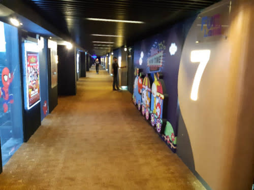 The cinema corridor adorned with posters at Cinehouse, One City Skypark.